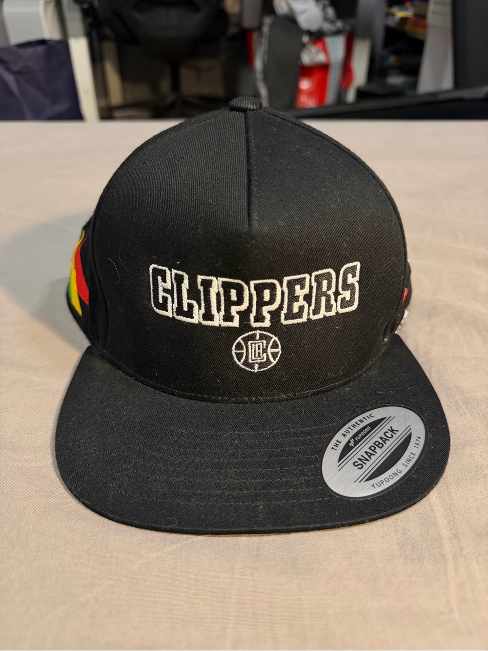 The Classic Black Clippers Snapback Hat with Rasta Side Stripes